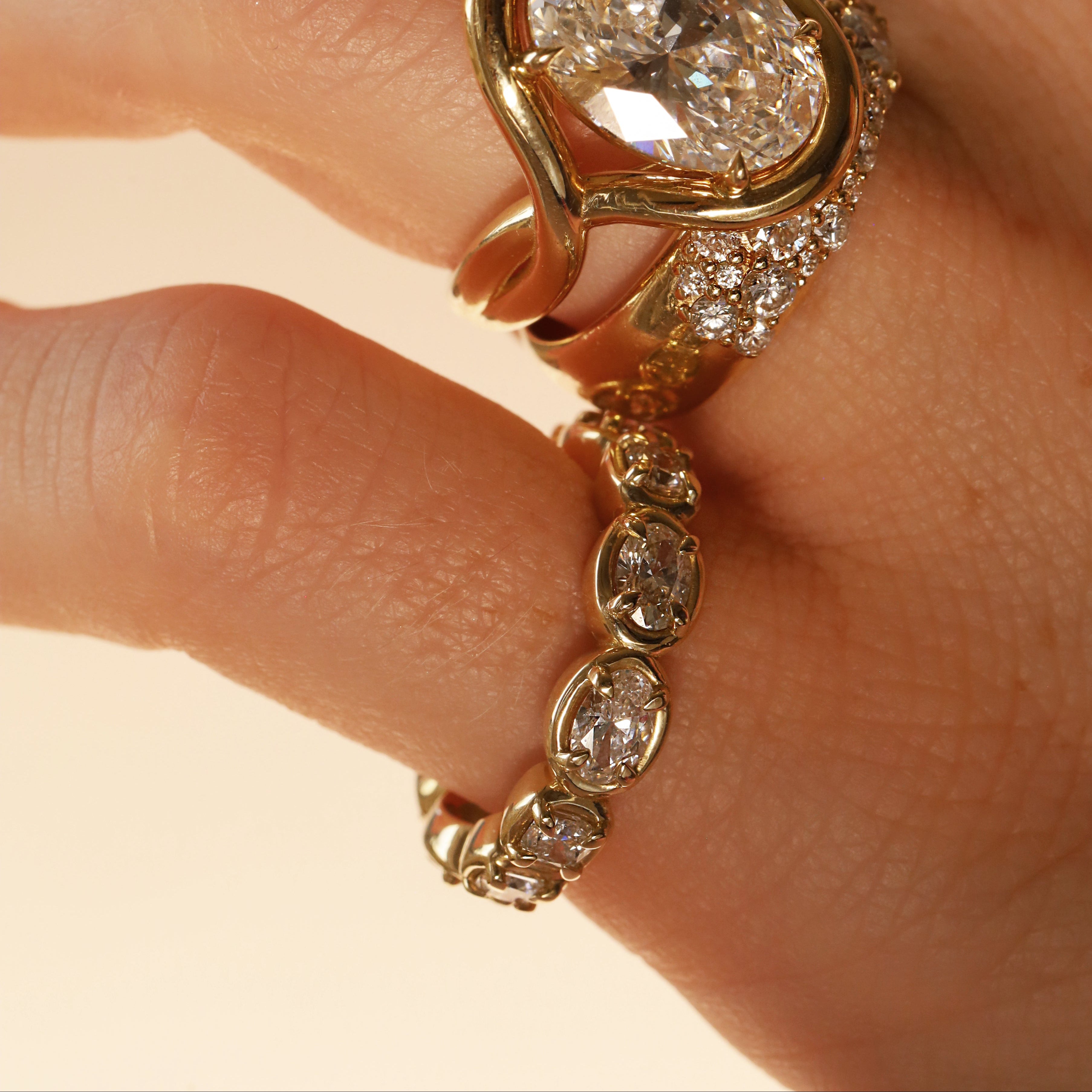 close up of woman's hands wearing multiple yellow gold and diamond rings