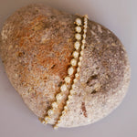 Gold bracelet on a textured rock surface