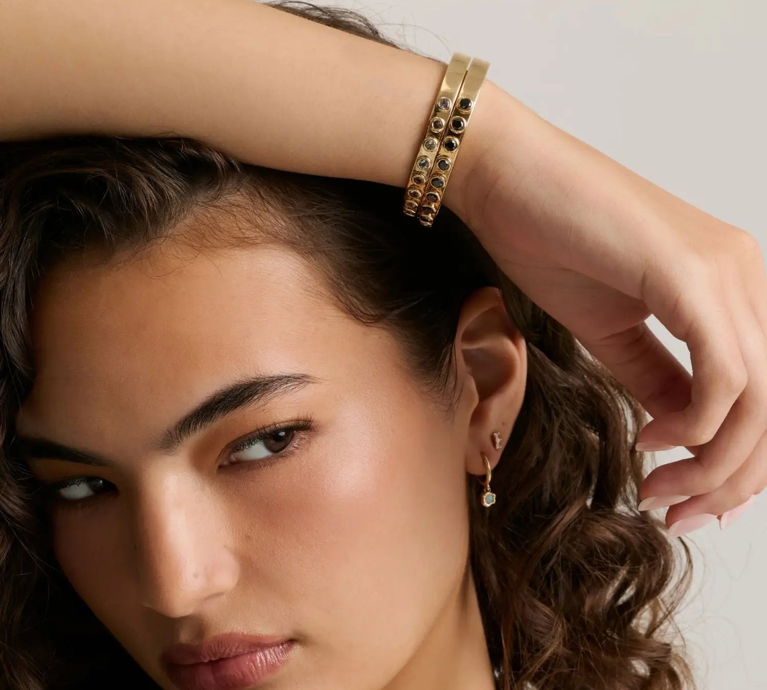 Model with curly hair wearing the Little Black Diamond Cuff on her wrist