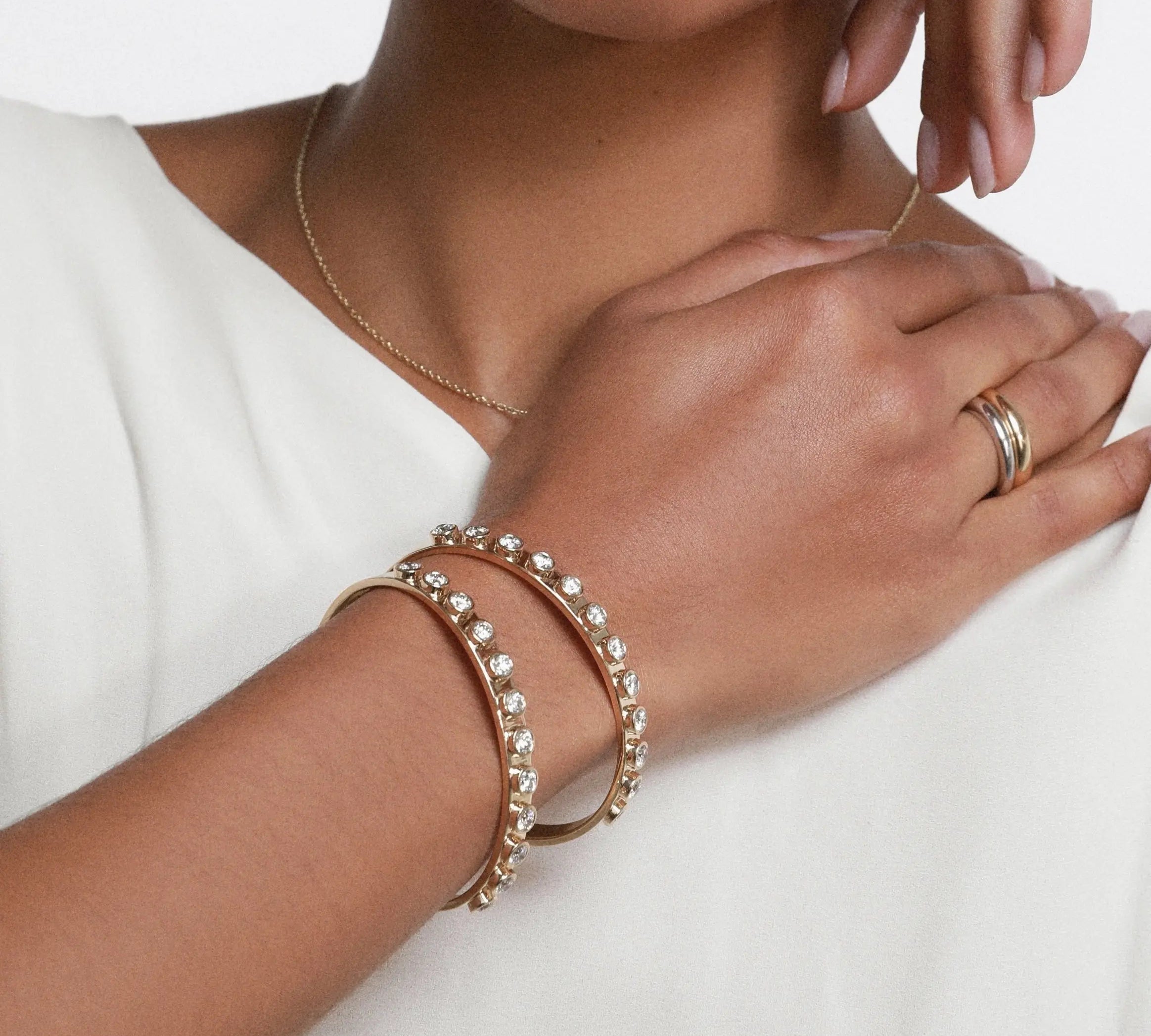 close up of woman's hand wearing two Marrow Fine Little White Diamond Cuffs