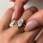 marquise diamond ring and gold twist ring on hand
