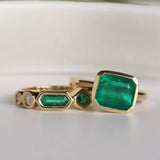 Gold rings with green gemstones on a white background
