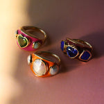 Three one-of-a-kind Marrakech enamel rings: a tanzanite heart on berry enamel, a baroque keshi pearl on burnt orange enamel and a peridot heart on hot pink enamel