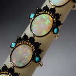 Close-up of a bracelet with opal stones and black accents on a dark background