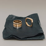 Two gold rings on a crumpled black paper background