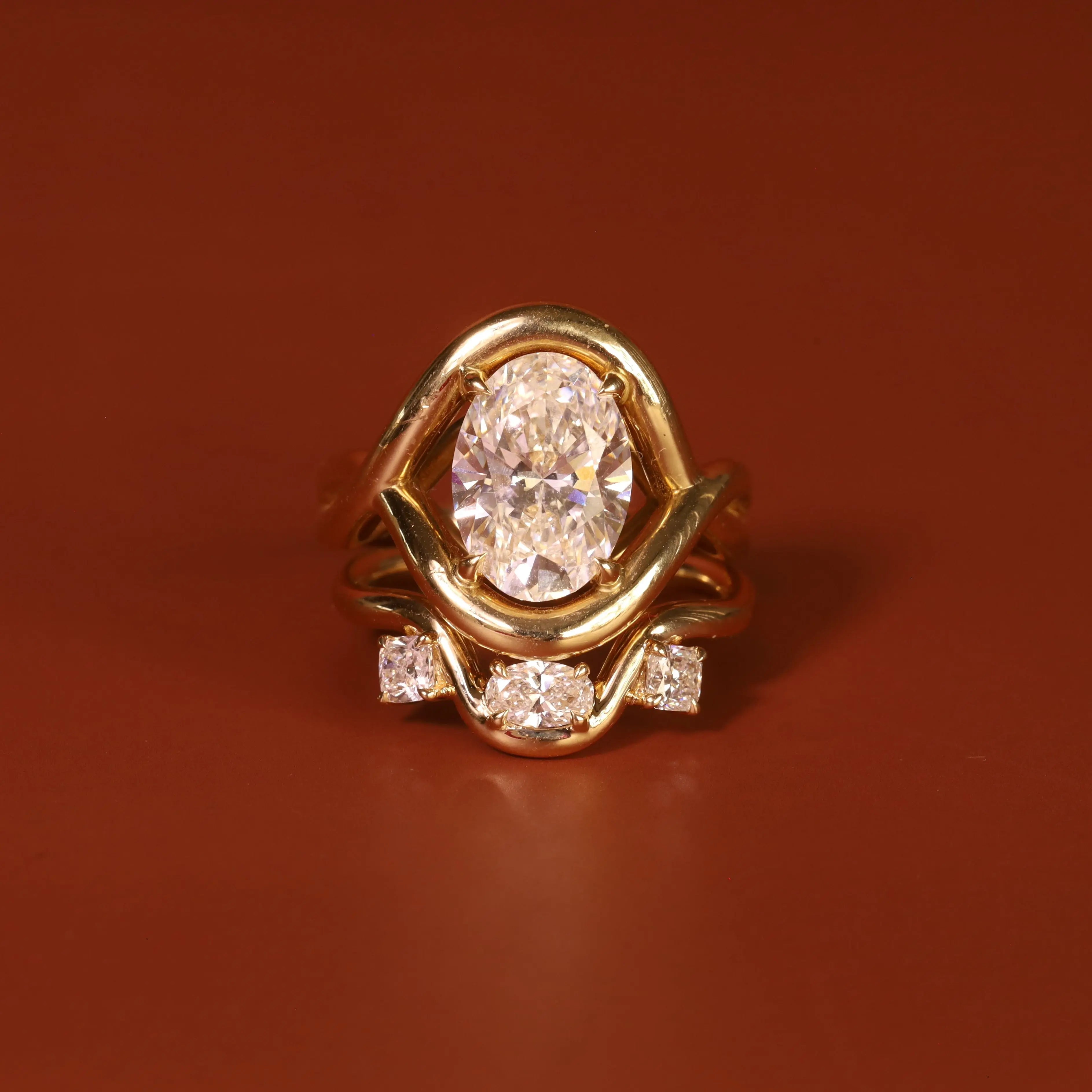 Gold ring with a diamond on a brown-red background