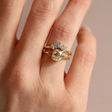 Gold ring with a diamond on a hand against a neutral background