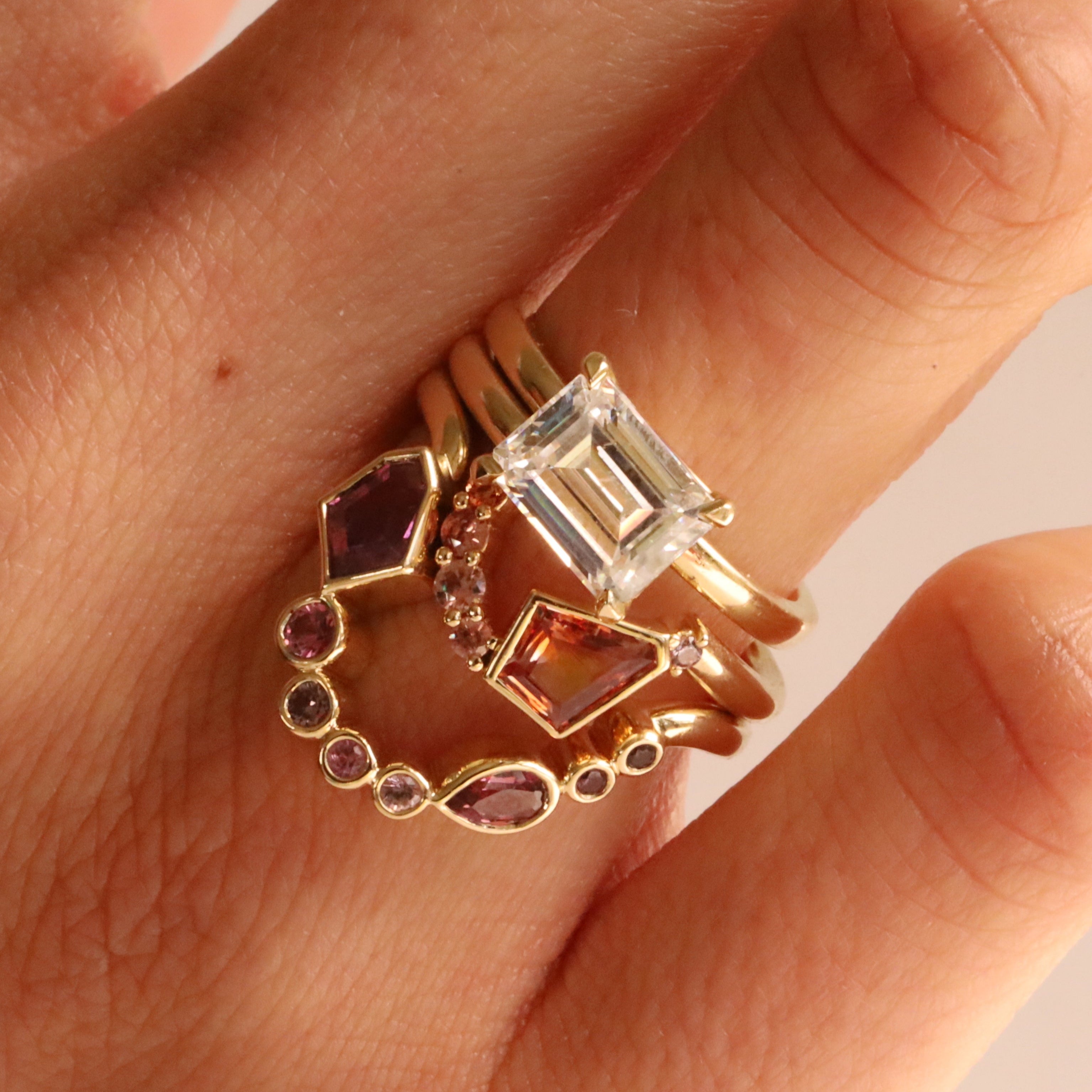 Close up of 0.66ct Winza Sapphire and Sapphire Lucy Band and 0.61ct Montana Sapphire & Malawi Sapphire Lucy Band stacked on woman's hand