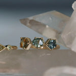Gold ring with green gemstones on a crystal background