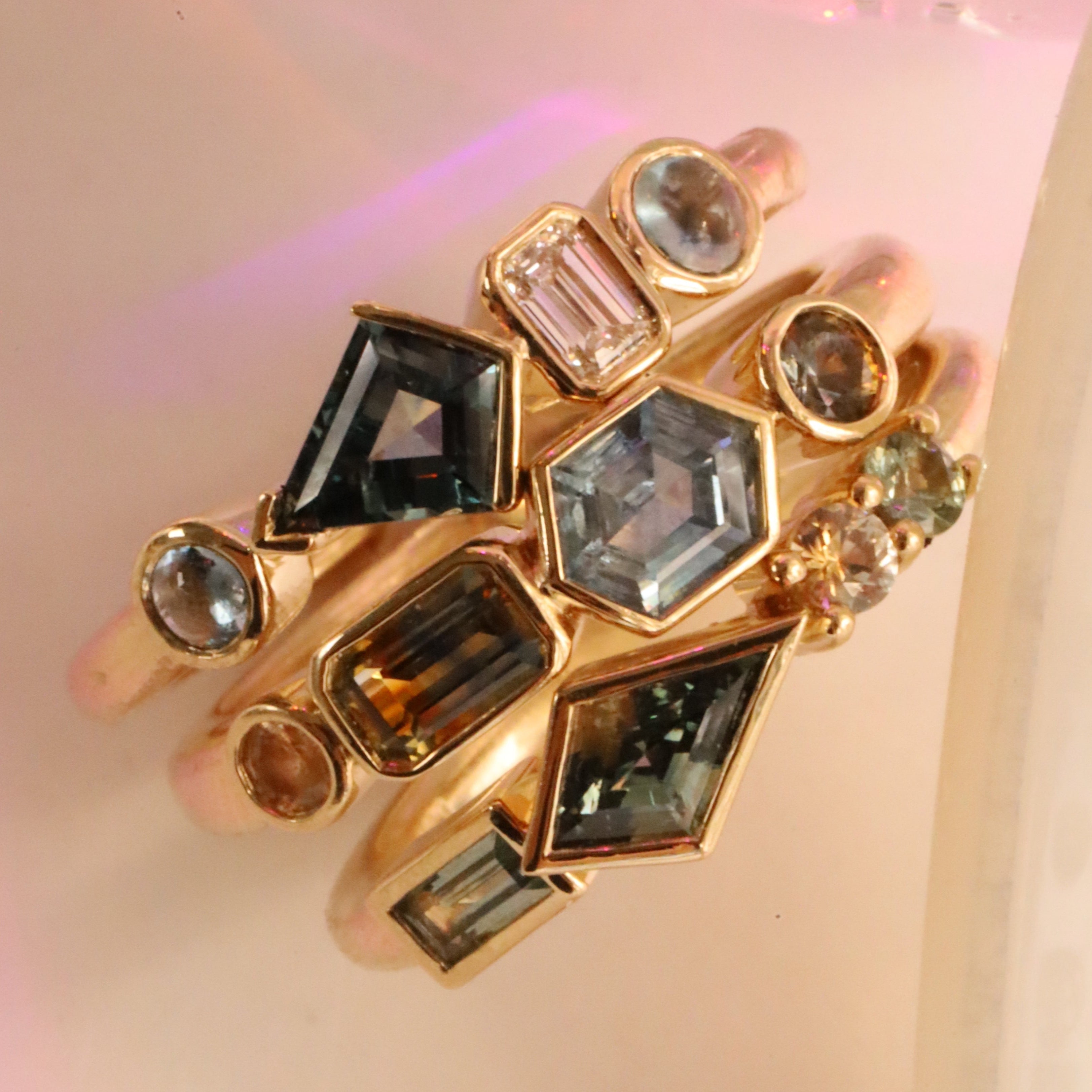 Flat lay of 1.08tcw Montana Sapphire Linear Ring + 0.52ct Montana Sapphire, Sapphire and Diamond Kaleidoscope Ring + 0.62ctw Montana Sapphire Linear Ring