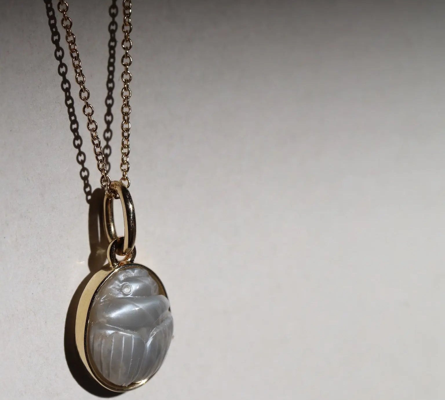 Moonstone Scarab Necklace against neutral background
