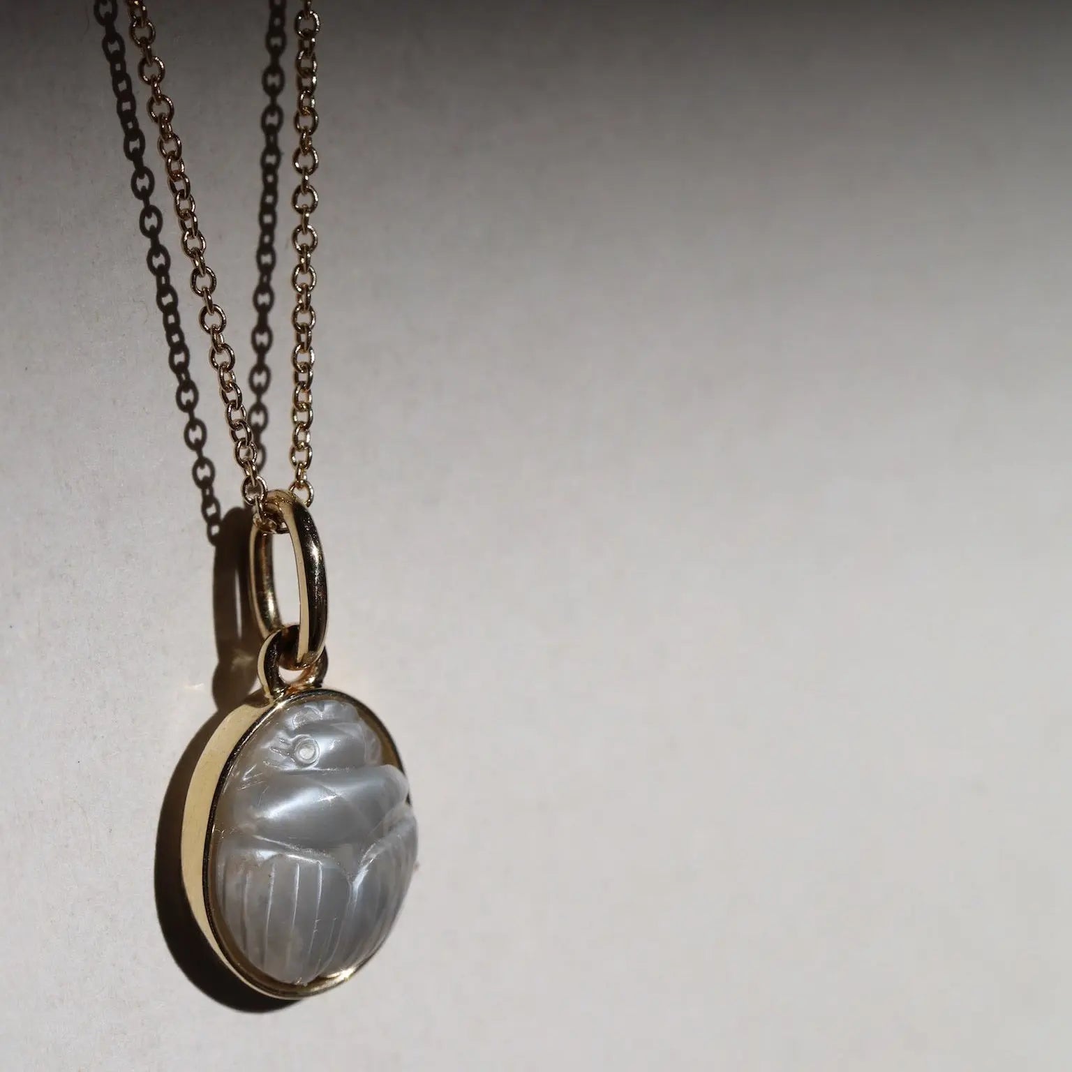 Moonstone Scarab Necklace against neutral background