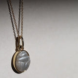 Moonstone Scarab Necklace against neutral background