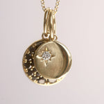 Gold pendant necklace with star design on a light gray background