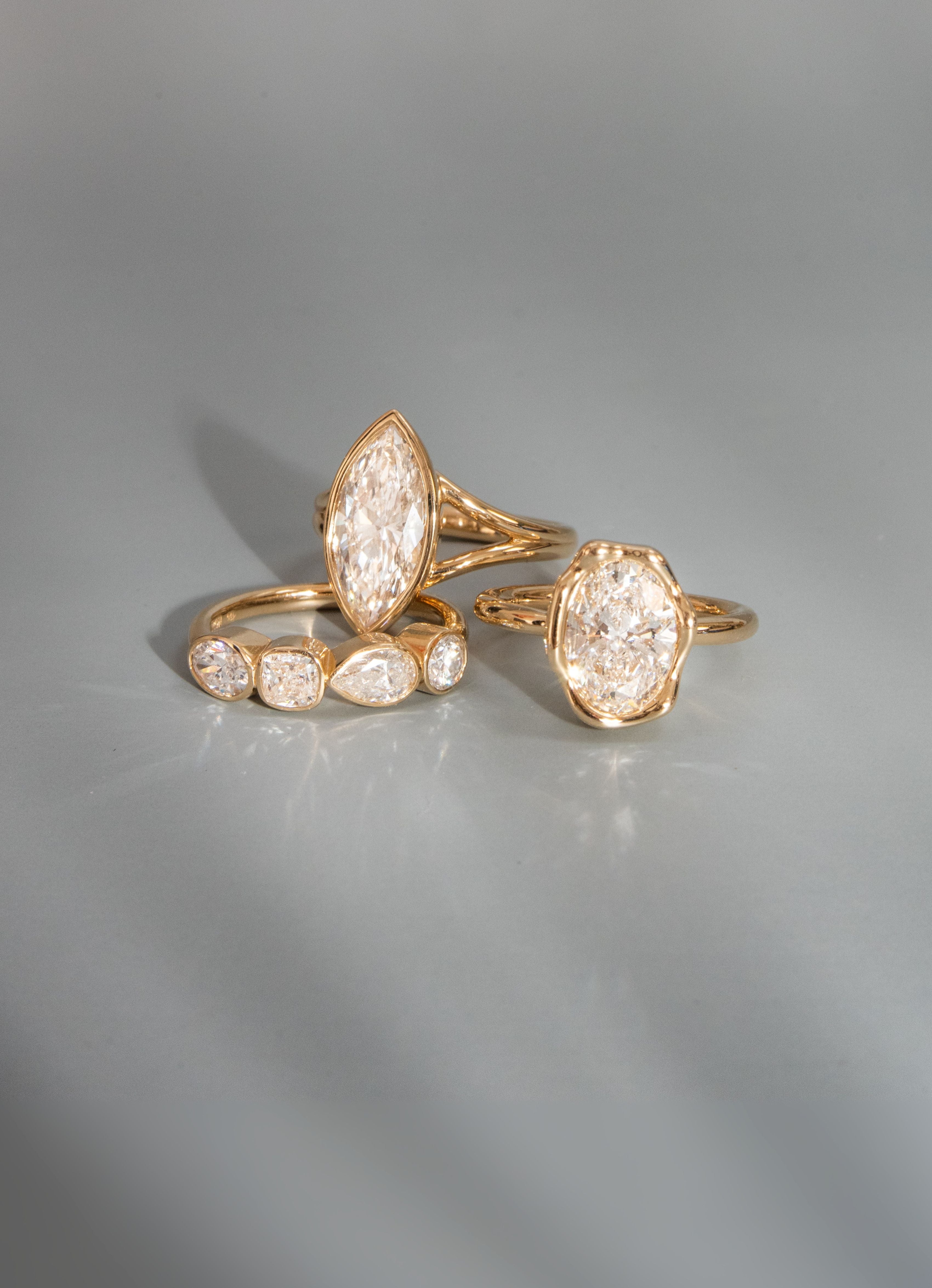 Gold rings with diamond-like stones on a gray background
