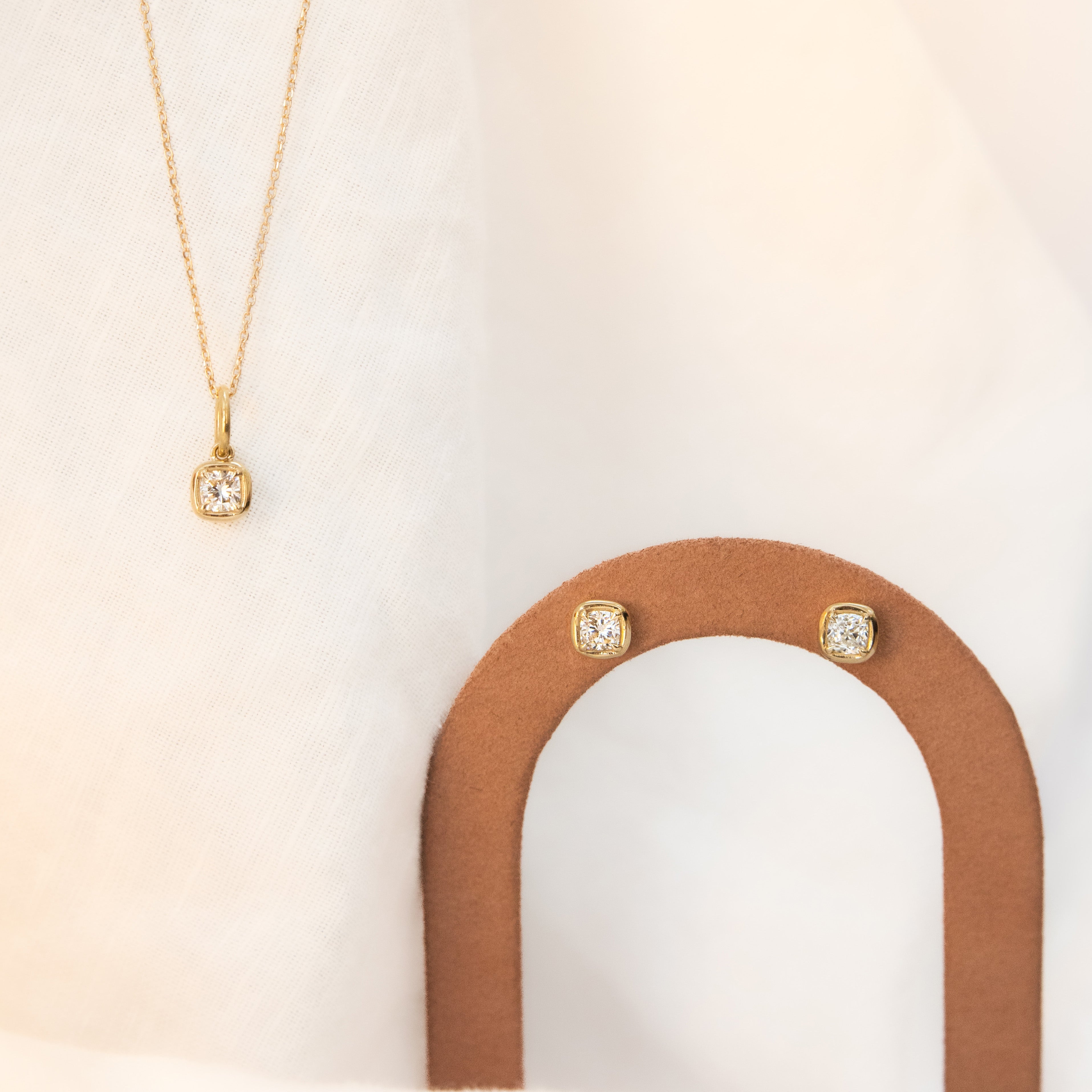 Flat lay of Nina Cushion Studs and Nina Cushion Pendant