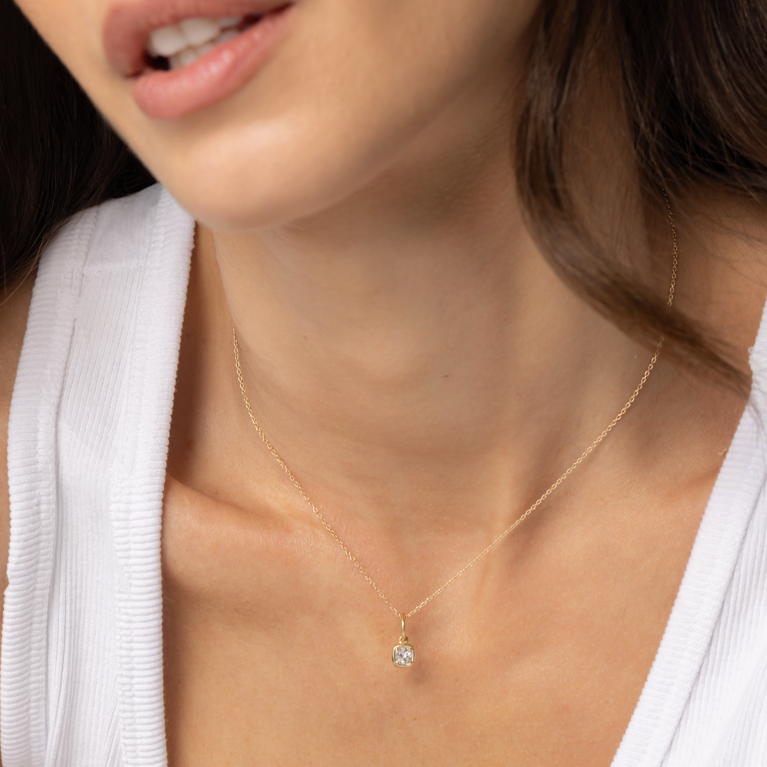 Close up of Nina Cushion Pendant on woman's décolletage 