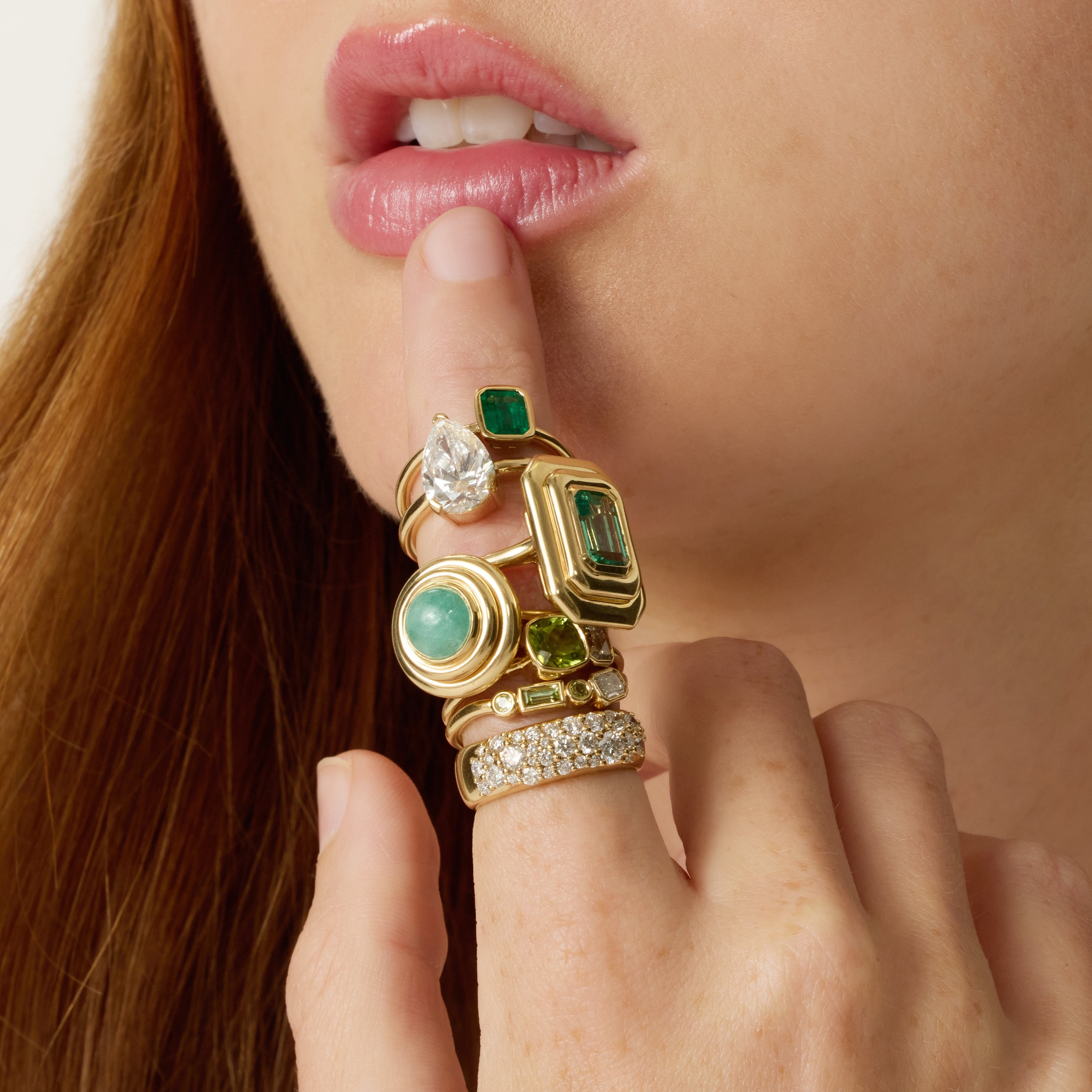 Close-up of a woman's face wearing a gold ring with gemstones.