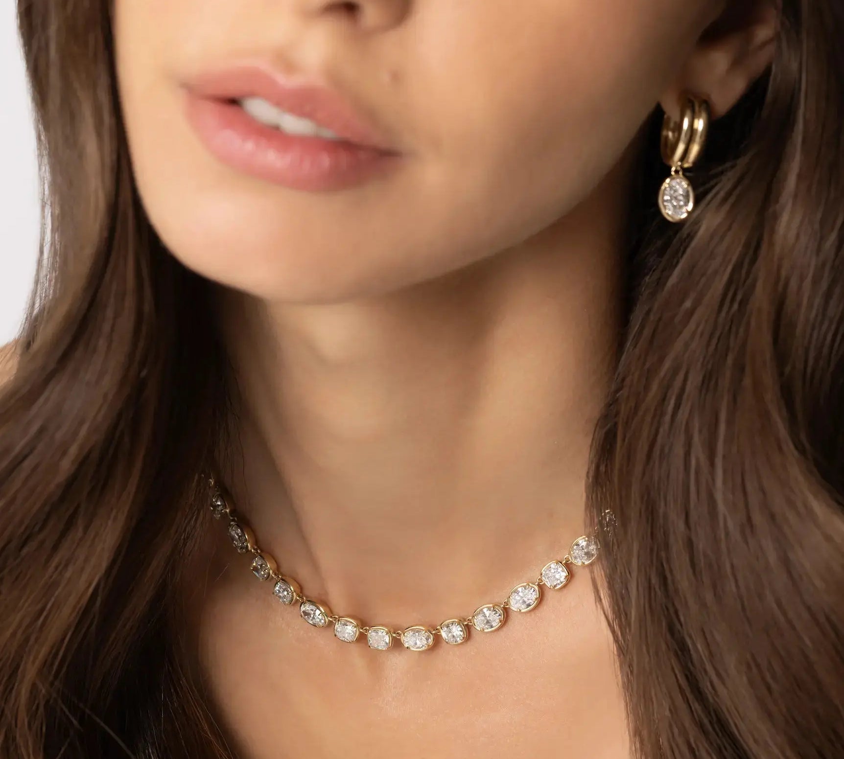 Close up of woman waring Odette Oval Drop Earrings and Lisse Tennis Necklace