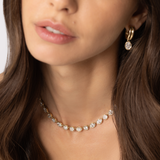 Close up of woman waring Odette Oval Drop Earrings and Lisse Tennis Necklace