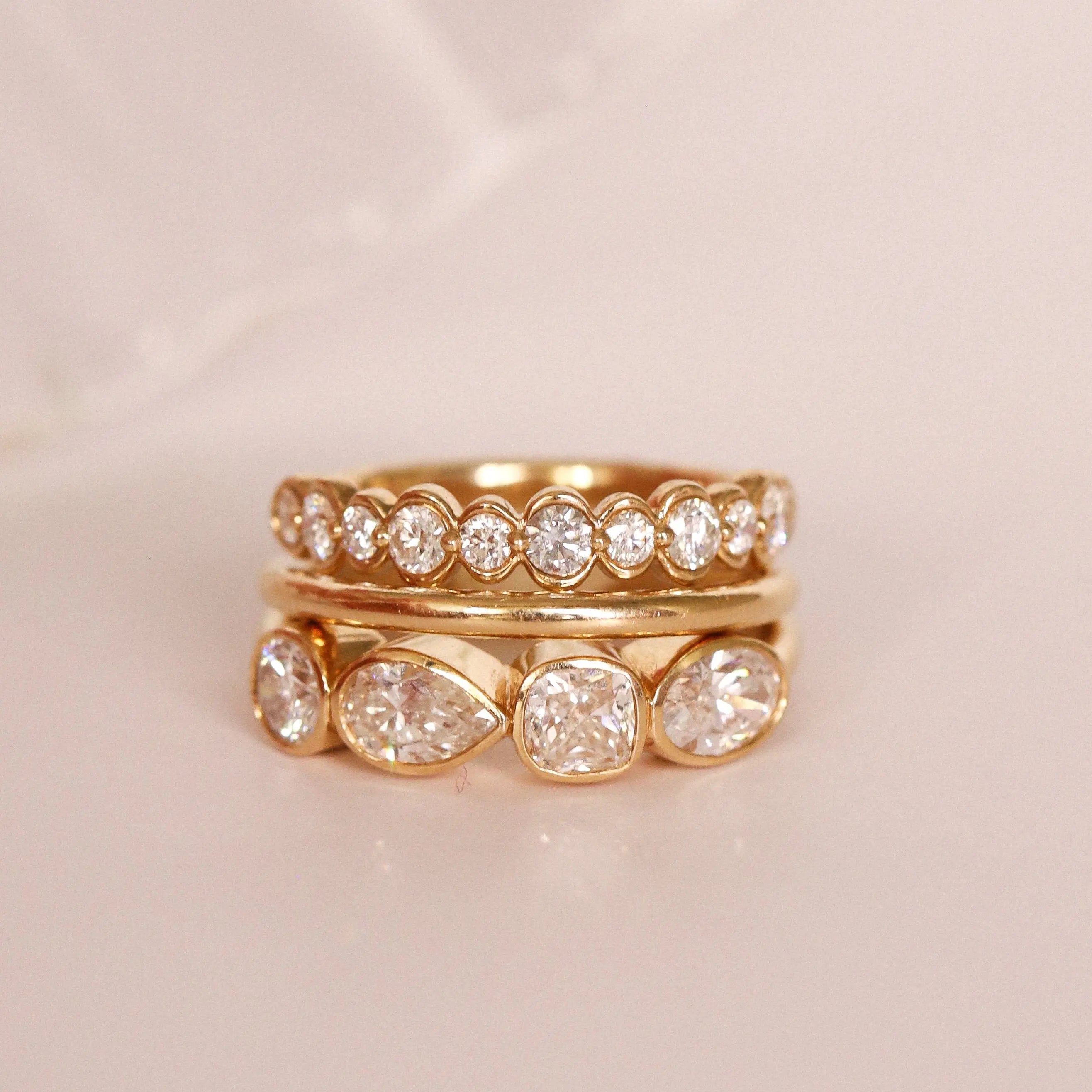 flat lay of diamond and gold bands on a pinkish background