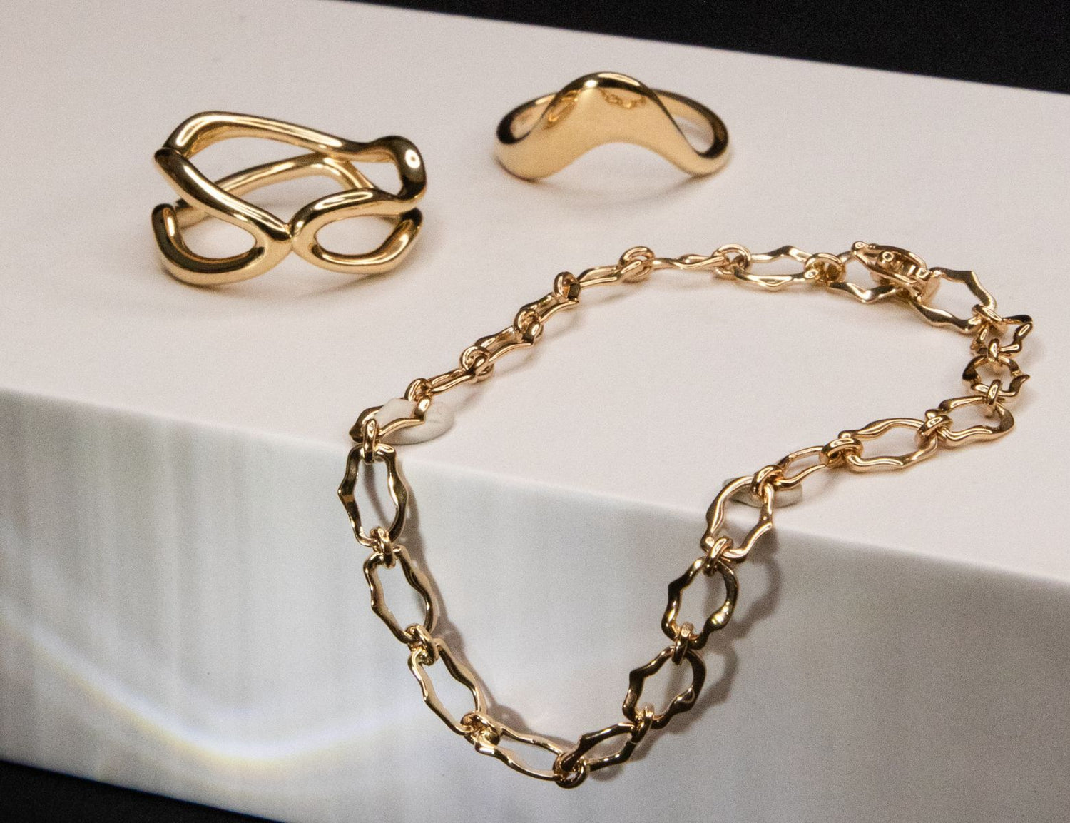 Flat lay of solid gold pieces from The Shape of Things Collection