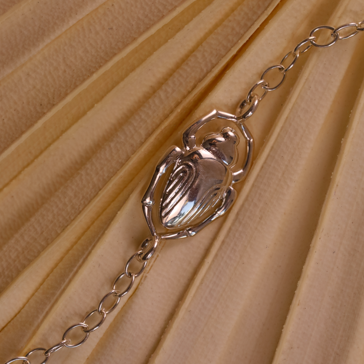 Silver bracelet with a decorative clasp on a beige fabric background