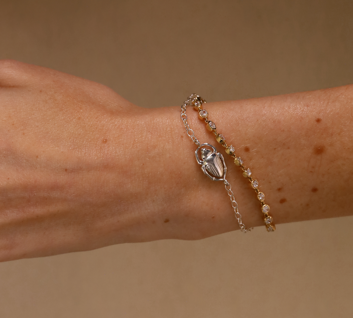 Bracelet with a decorative clasp on a wrist against a beige background