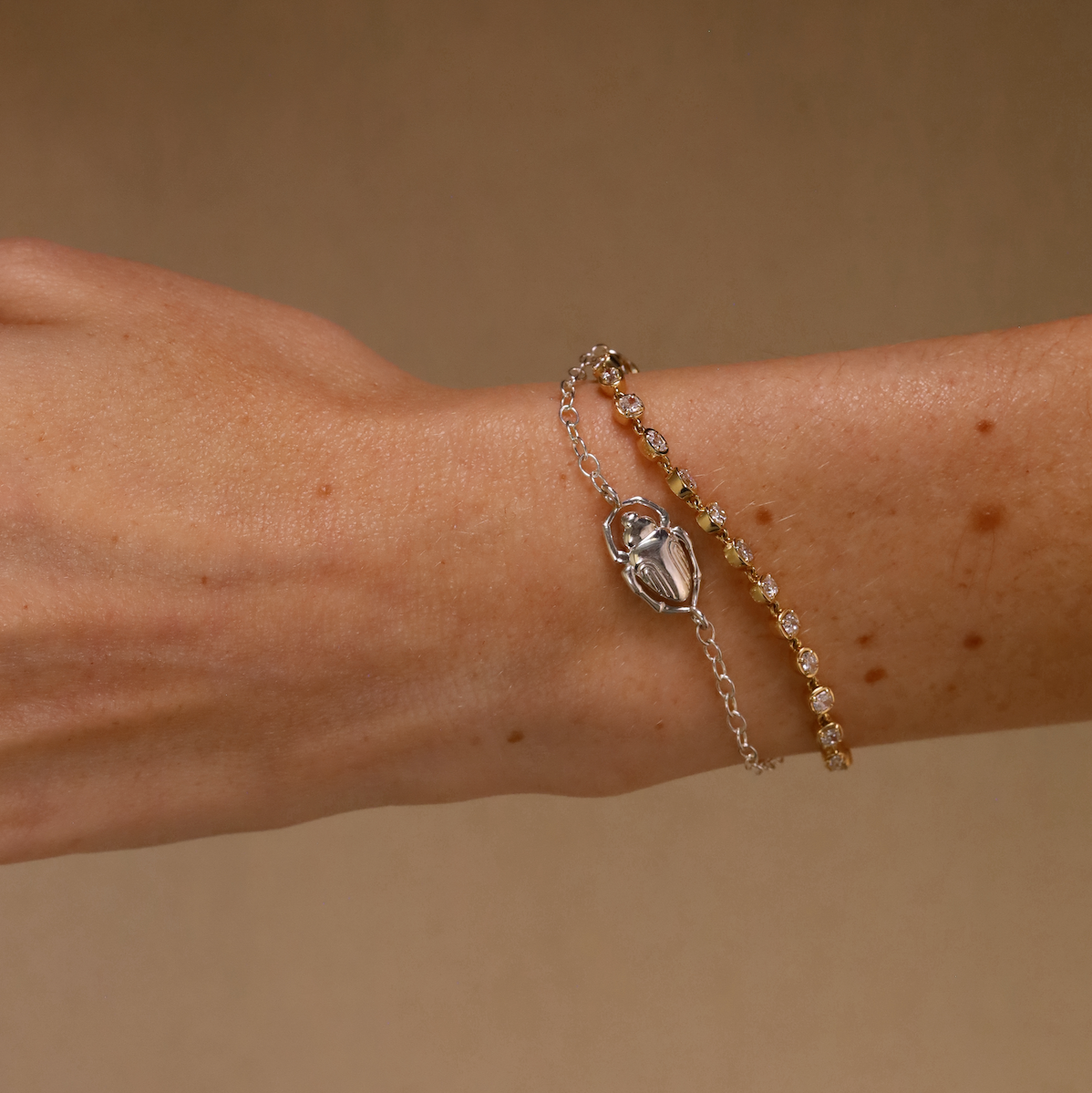 Bracelet with a decorative clasp on a wrist against a beige background