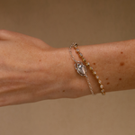 Bracelet with a decorative clasp on a wrist against a beige background