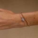 Bracelet with a decorative clasp on a wrist against a beige background