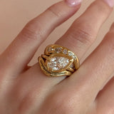 Gold ring with a diamond on a hand against a beige background