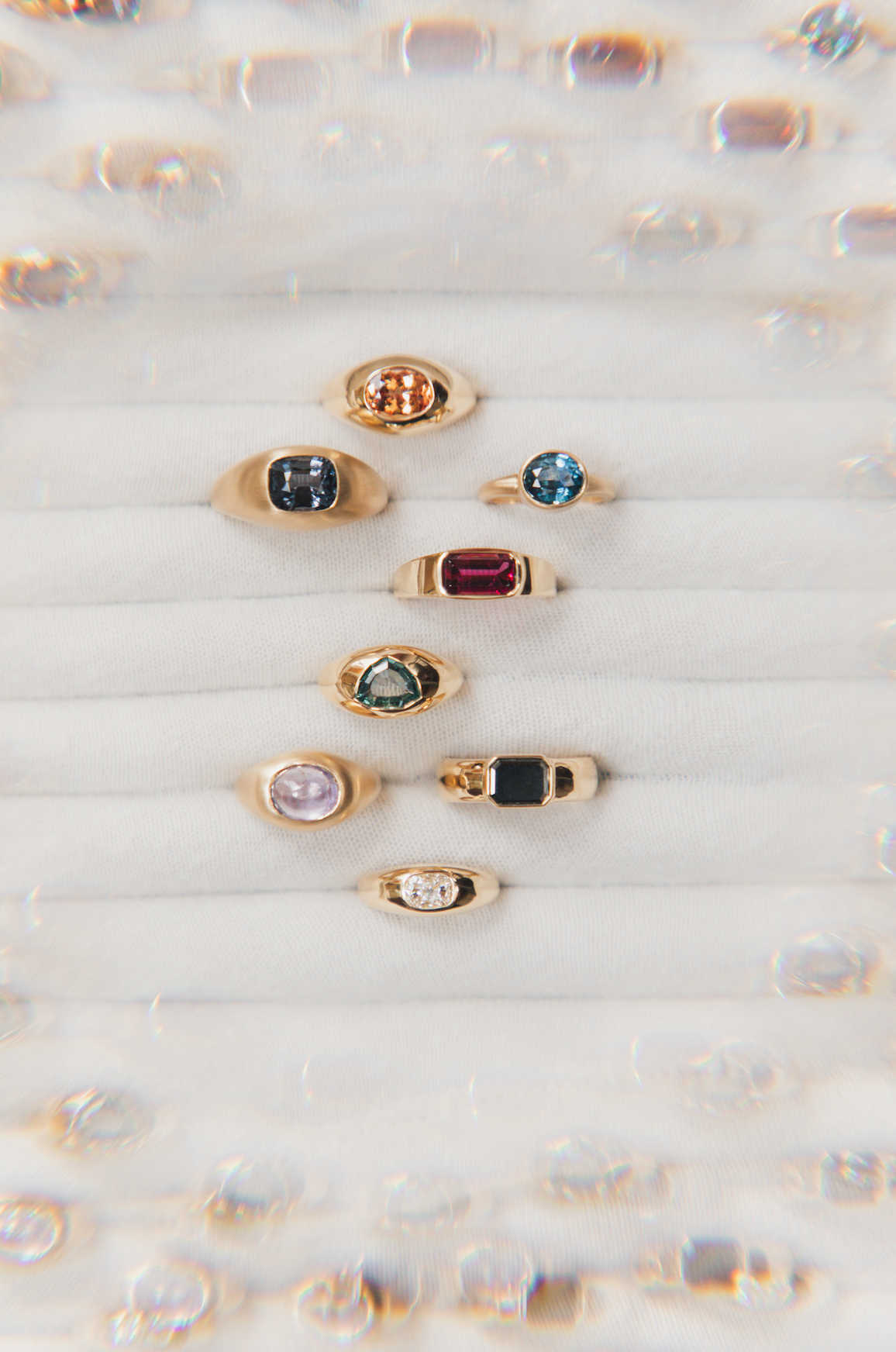 Overhead shot of one-of-a-kind Marrow rings with different colored gemstones 