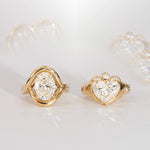 Gold rings with heart-shaped diamond designs on a light background
