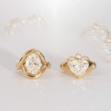 Gold rings with heart-shaped diamond designs on a light background