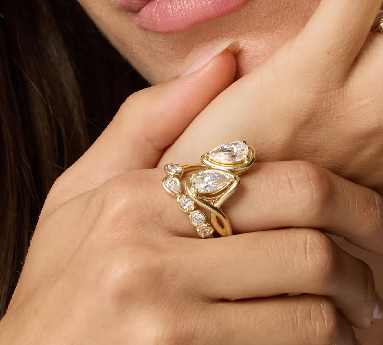 Close up of Joanie Bypass Ring and Simone Arch Band stacked on woman's finger