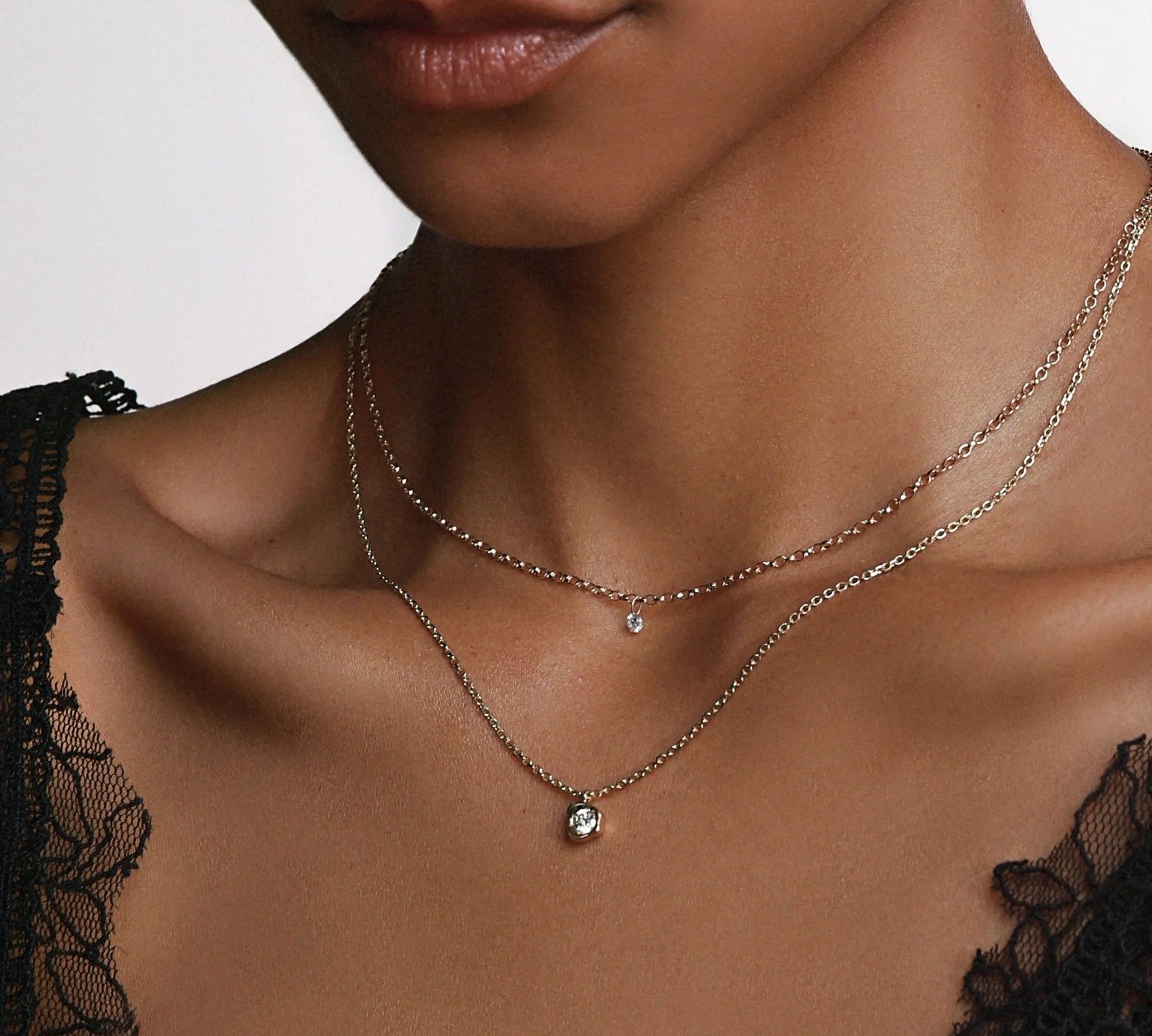 close up of woman's décolletage wearing the Marrow Fine Single Diamond Drop Choker styled with the White Diamond Abstract Bezel Pendant