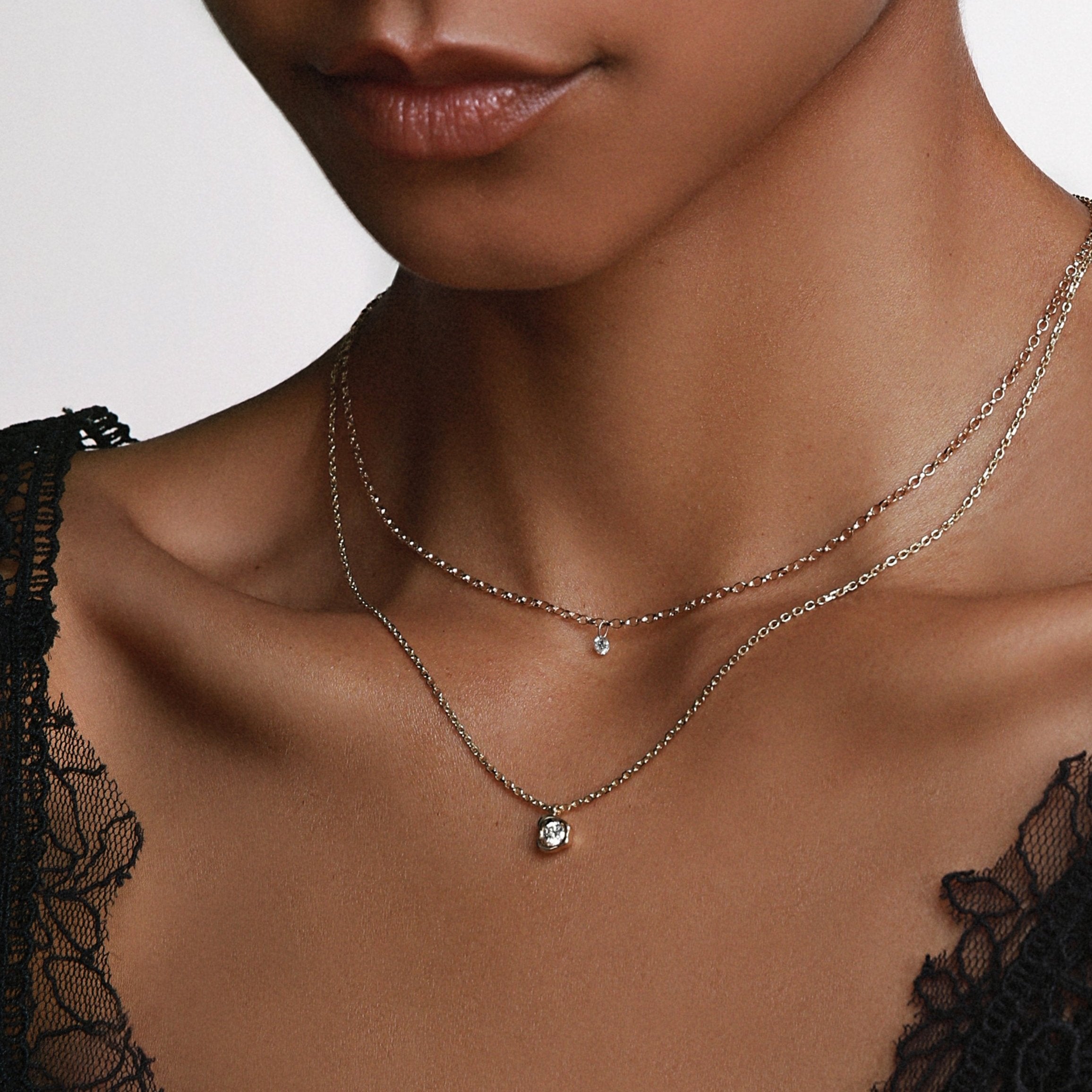 close up of woman's décolletage wearing the Marrow Fine Single Diamond Drop Choker styled with the White Diamond Abstract Bezel Pendant