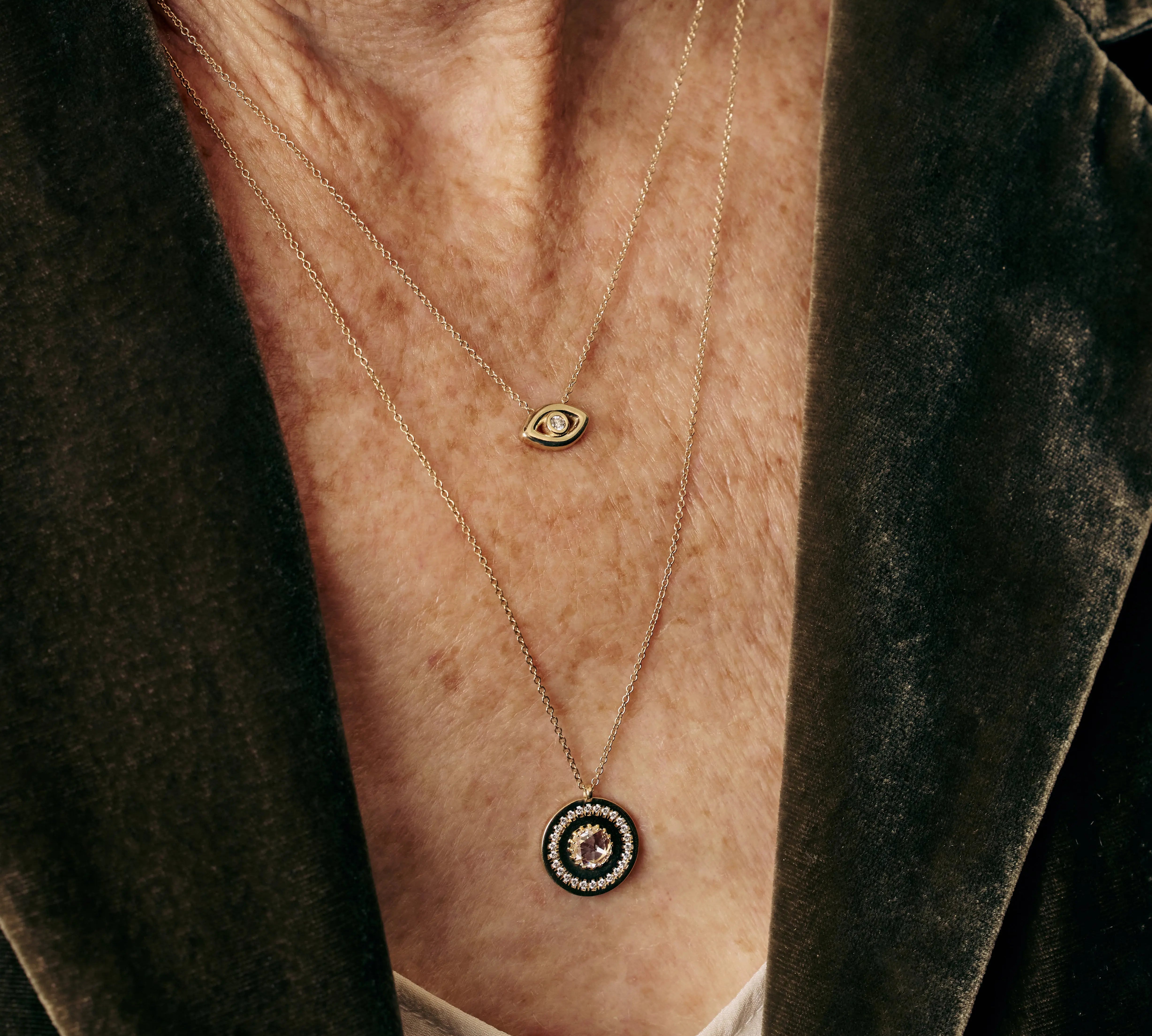 Necklace with an eye-shaped pendant worn by a person against a dark background