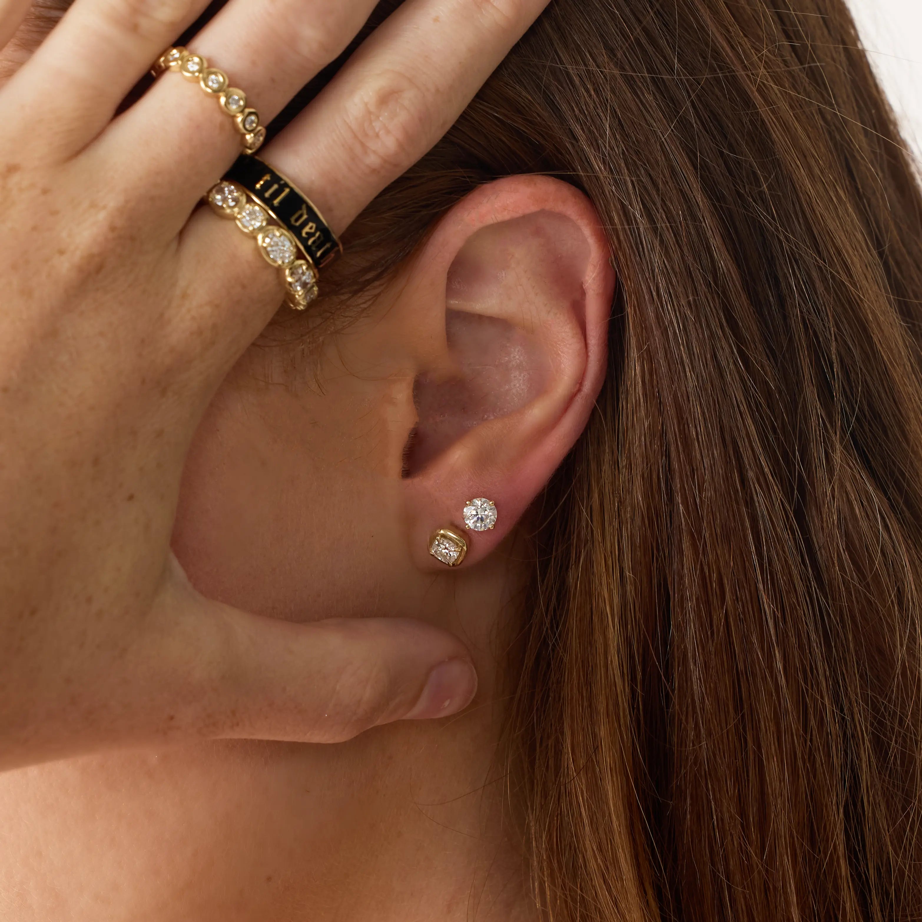close up of woman's hear wearing Marrow Fine diamond studs and rings