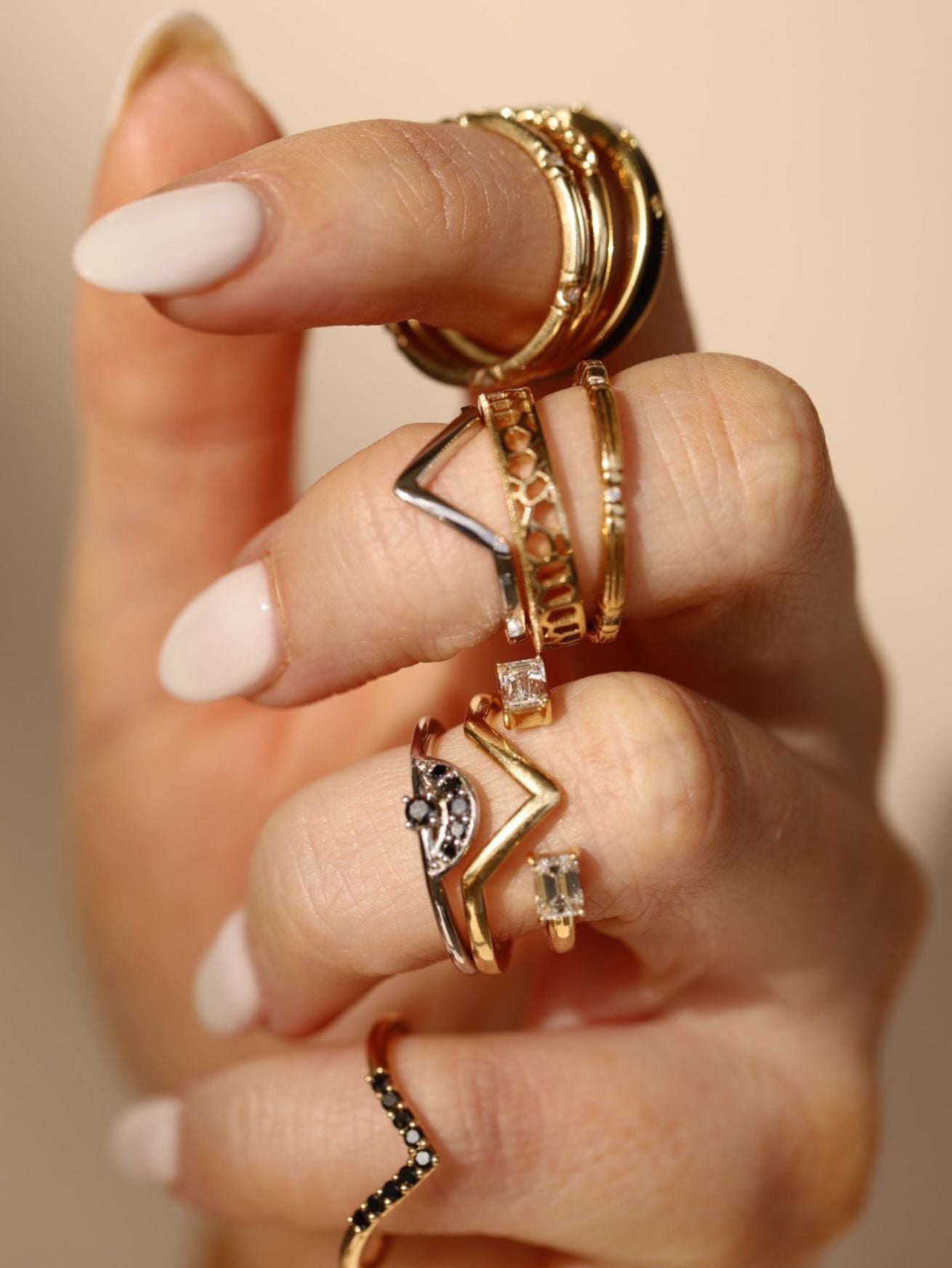 Close up of woman's hand with multiple rings stacked on knuckles
