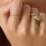 Close-up of a hand wearing two gold rings with gemstones.
