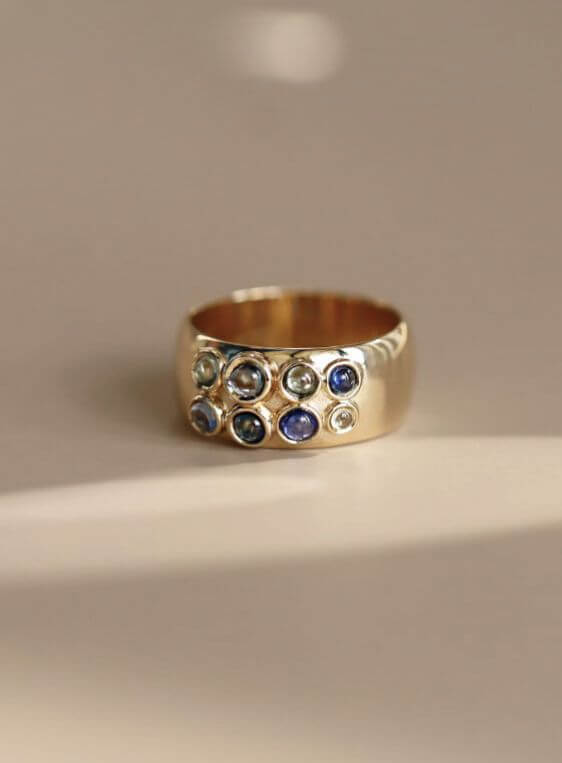 photo of a cigar band ring from the Kaleidoscope collection, featuring sapphire cabochons