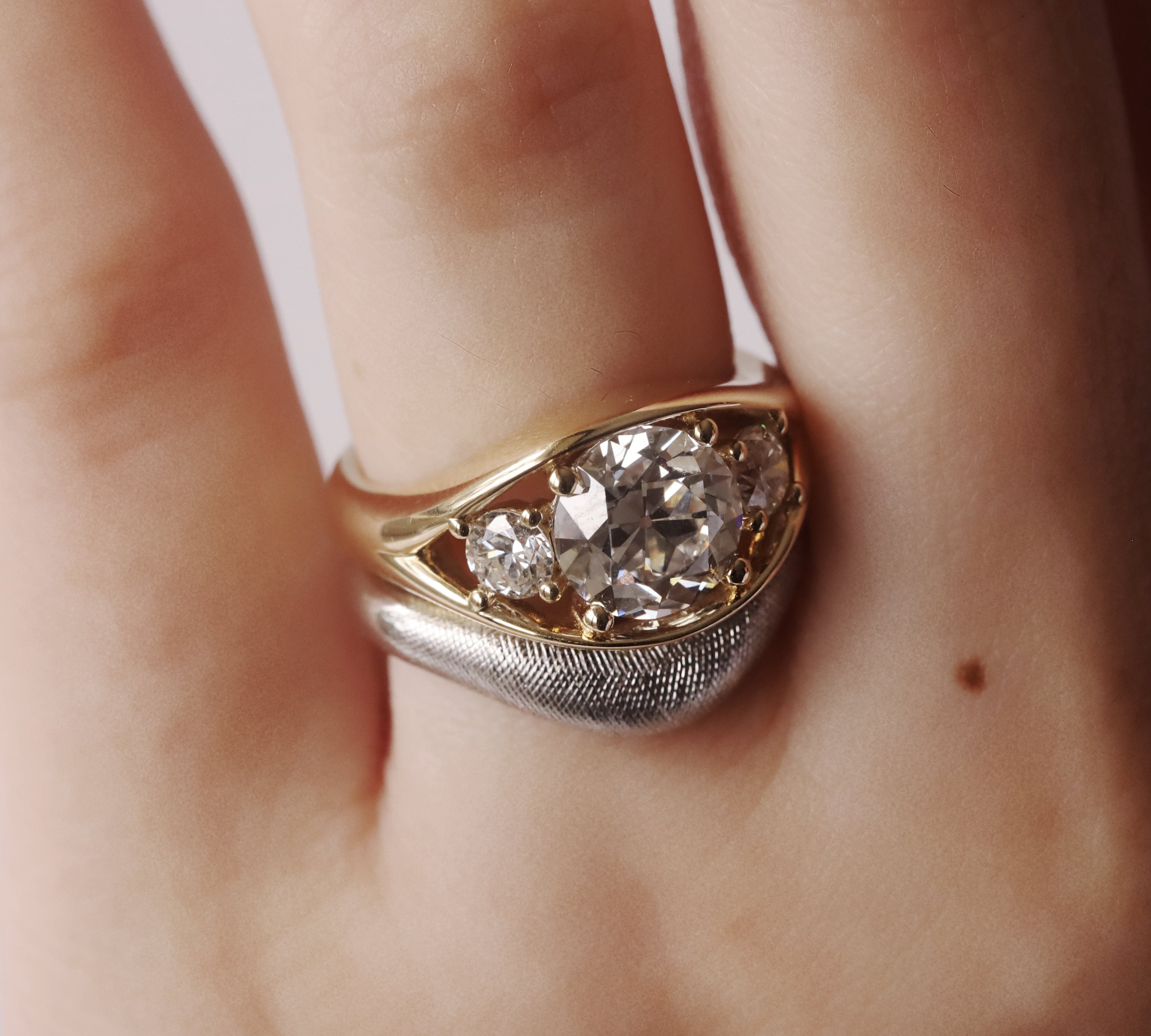 Gold and silver ring with diamonds on a finger