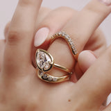 Gold ring with a pear-shaped diamond on a hand