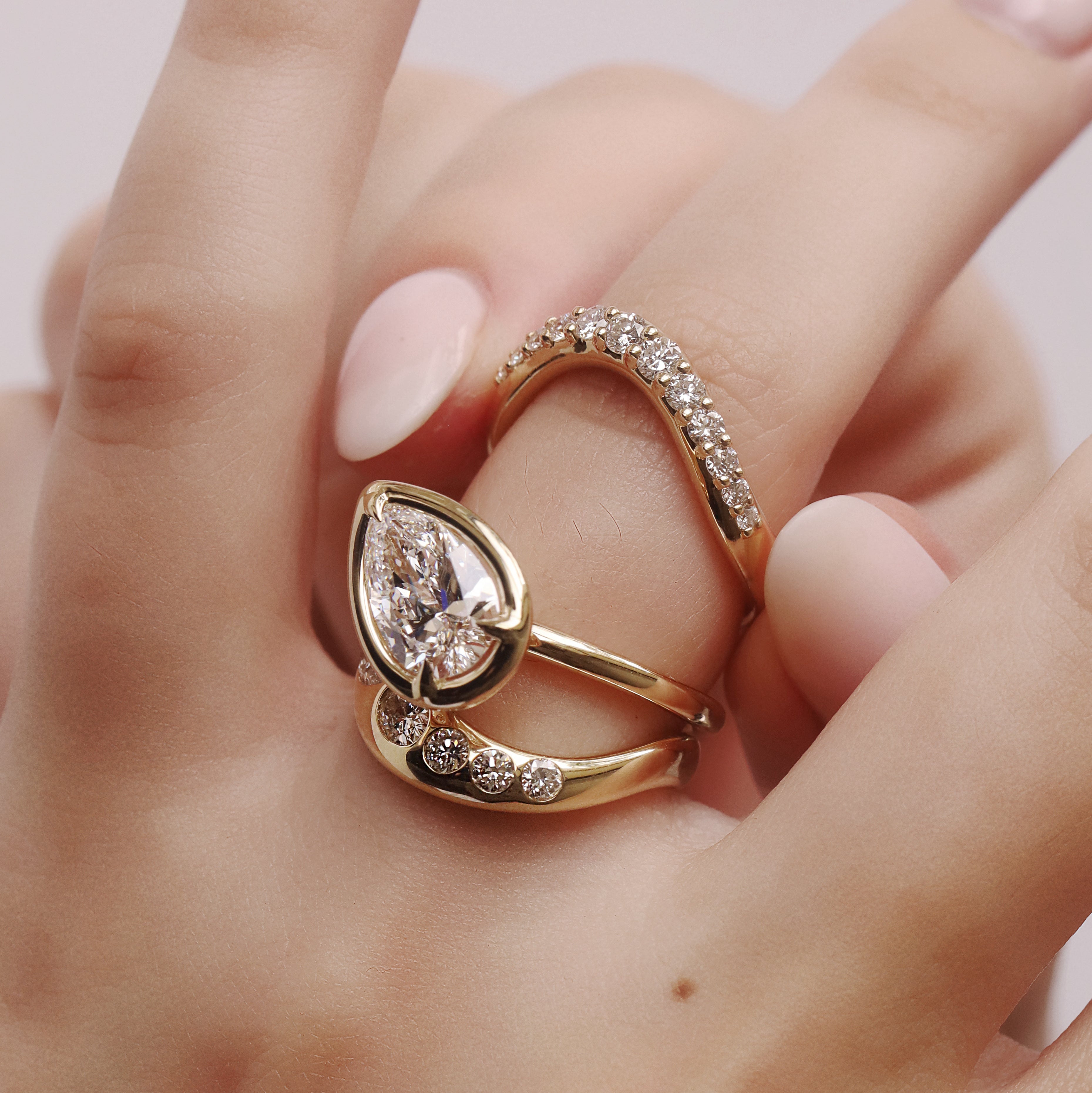 Gold ring with a pear-shaped diamond on a hand