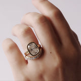 Hand wearing a diamond ring on a plain background