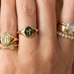 Close-up of a hand wearing multiple gold rings with different designs.