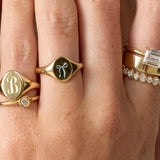 Close-up of a hand wearing multiple gold rings with different designs.