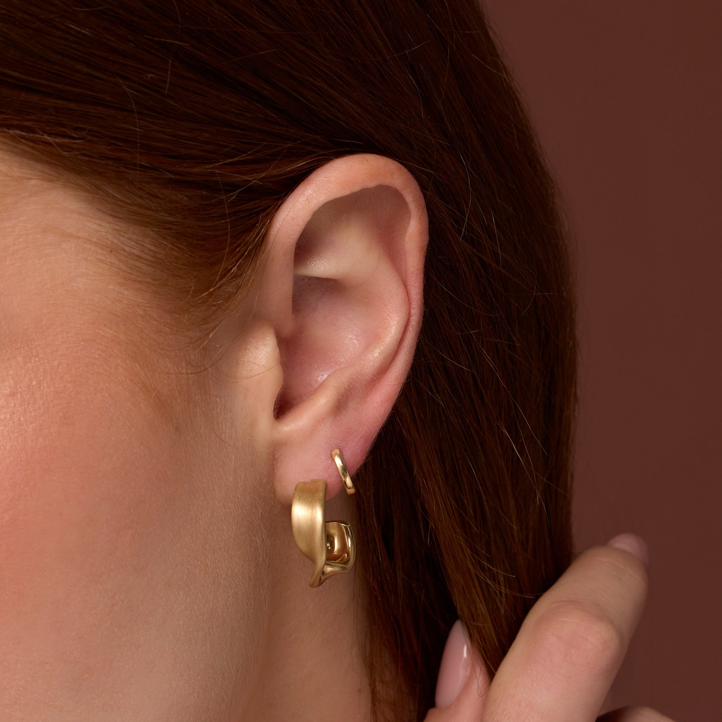 Close up of woman's ear wearing Everyday Twist Hoops